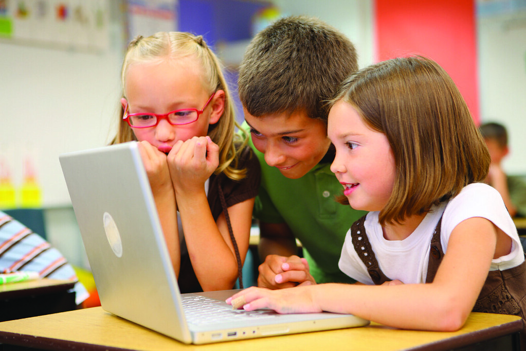 students gathered around laptop